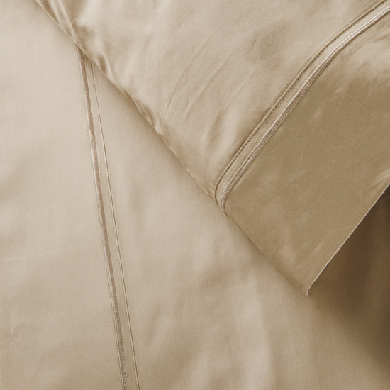 Juego de sábanas beige con festón y costura decorativa visible-