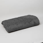 
                    
                      Frazada polar gris oscuro enrollada sobre fondo blanco-gris-oscuro
                    
                  