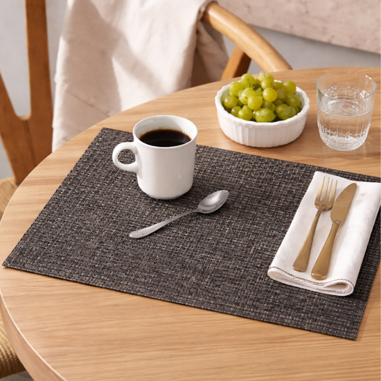 Placemat gris tejido con café, grapes y cubiertos dorados-
