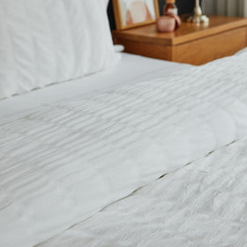 Funda edredón blanco con patrón de bastones sobre cama de madera-blanco