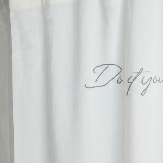 Cortina blanca con texto "Do it you" escrito en gris-gris