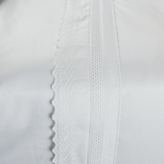 Detalle de sábana blanca con bordados y encaje en algodón egipcio-blanco