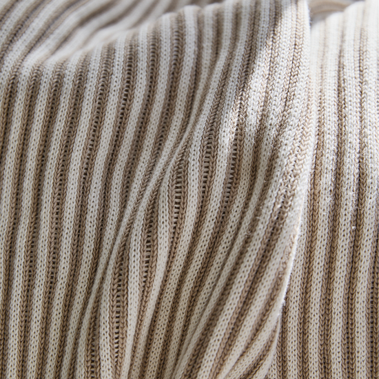 Detalle texturizado de manta beige con patrón de costillas verticales-beige