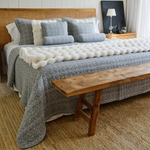 
                    
                      Cubrecama Leicester gris sobre cama con almohadas decorativas y banco de madera-gris
                    
                  