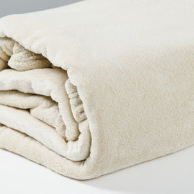 Frazada polar beige enrollada mostrando textura suave y acogedora-natural