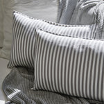 
                    
                      Almohada Capri gris con rayas blancas sobre manta textil-gris
                    
                  
