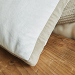 
                    
                      Almohada beige clara sobre superficie de madera con texturas naturales-beige
                    
                  