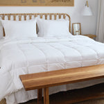 
                    
                      Cama con edredón blanco antibacterial y almohadas sobre cabecera de ratán-blanco
                    
                  