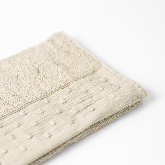 Toalla beige Yucca con textura de puntos decorativos en relieve-beige