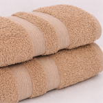 
                    
                      Set de toallas beige apiladas mostrando textura suave y lisa-
                    
                  