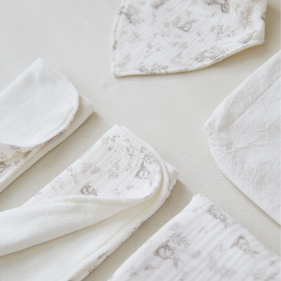 Conjunto de ropa blanca de bebé con detalles florales grises-