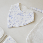 
                    
                      Babero blanco con estampado floral azul y cierre a presión-
                    
                  