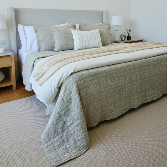 Cubrecama Bradford beige sobre cama con almohadas decorativas a juego-beige