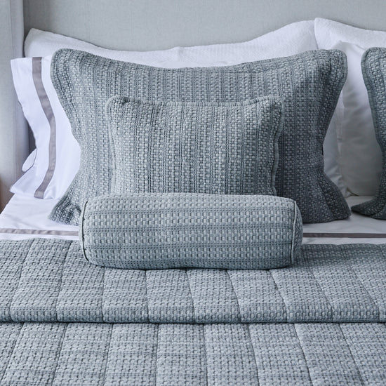 Cubrecama gris Bradford con almohadas texturadas en cama elegante-gris