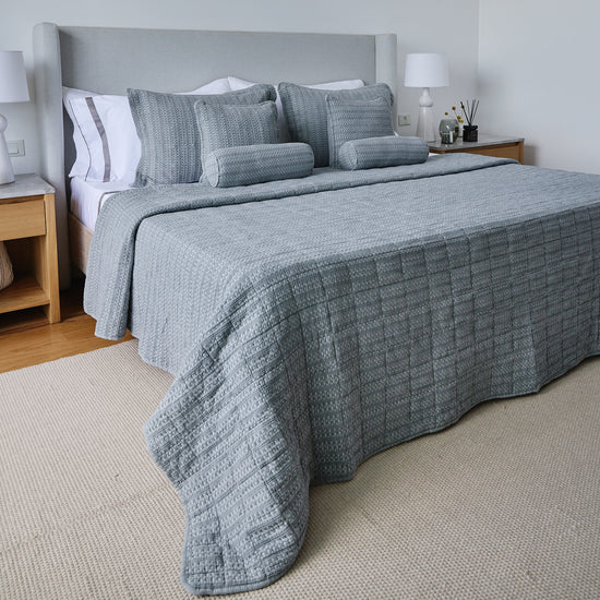Cubrecama gris Bradford con almohadas decorativas en cama con cabecera-gris