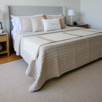 
                    
                      Cama con cubrecama beige acolchado y almohadas decorativas en dormitorio-beige
                    
                  