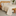 Cubrecama California beige con patrón de cruces en cama de madera-gris