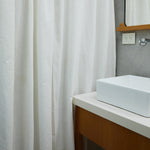 
                    
                      Cortina blanca de baño con patrón de lino en baño moderno-natural
                    
                  