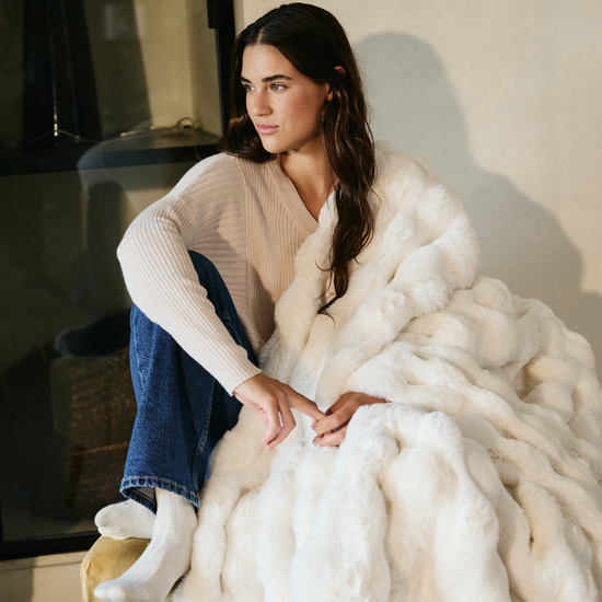 Mujer sentada luciendo manta blanca de textura bubble suave-