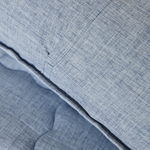 
                    
                      Detalle de cubrecama azul con textura de tela y costura decorativa-azul
                    
                  