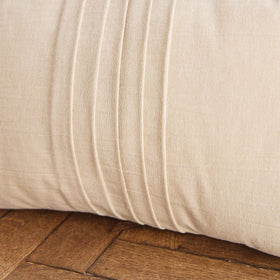 Almohada rectangular gris claro con detalles de pliegues en el centro-gris claro