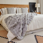 
                    
                      Cama con manta de piel simulada gris y almohadas decorativas-
                    
                  