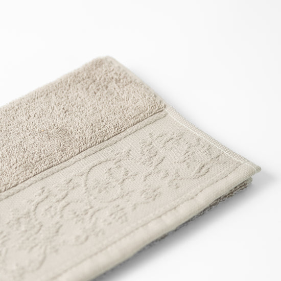 Toalla Malva beige texturizada con borde decorativo tejido-