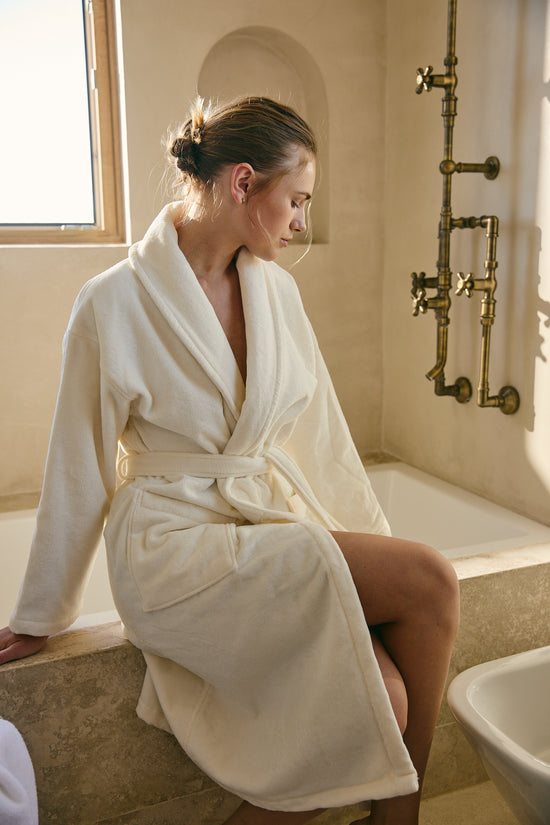 Mujer con bata blanca natural sentada en bañera de baño-natural