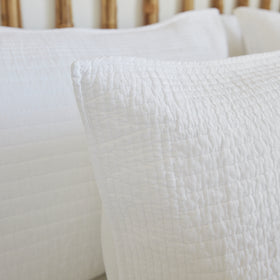 Funda de almohón Lugano blanco con textura acolchada en cama-blanco
