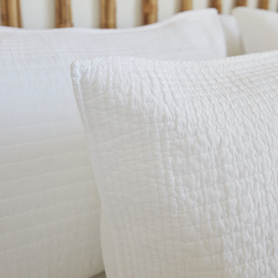 Funda de almohón Lugano blanco con textura acolchada en cama-blanco