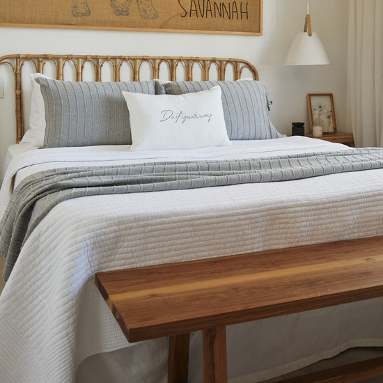 Cama con cubrecama blanco Lugano, almohadas grises y decoración minimalista-blanco