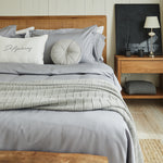 
                    
                      Almohada capitoné gris redonda sobre cama con sábanas grises-gris
                    
                  