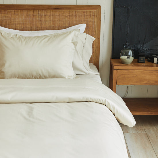 Cama con funda de edredón blanca de algodón bambú y almohadas-natural