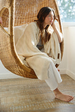 
                    
                      Manta de lana natural con patrón de líneas texturizadas y etiqueta Home Harmony-natural
                    
                  