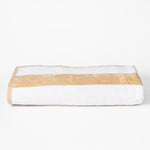 
                    
                      Toalla de playa blanca con franja horizontal beige doblada-azul
                    
                  