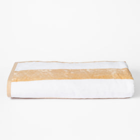 Toalla de playa blanca con franja horizontal beige doblada-azul