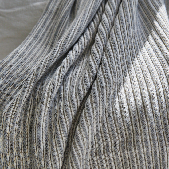 Manta gris de lana con textura acanalada y pliegues suaves-gris