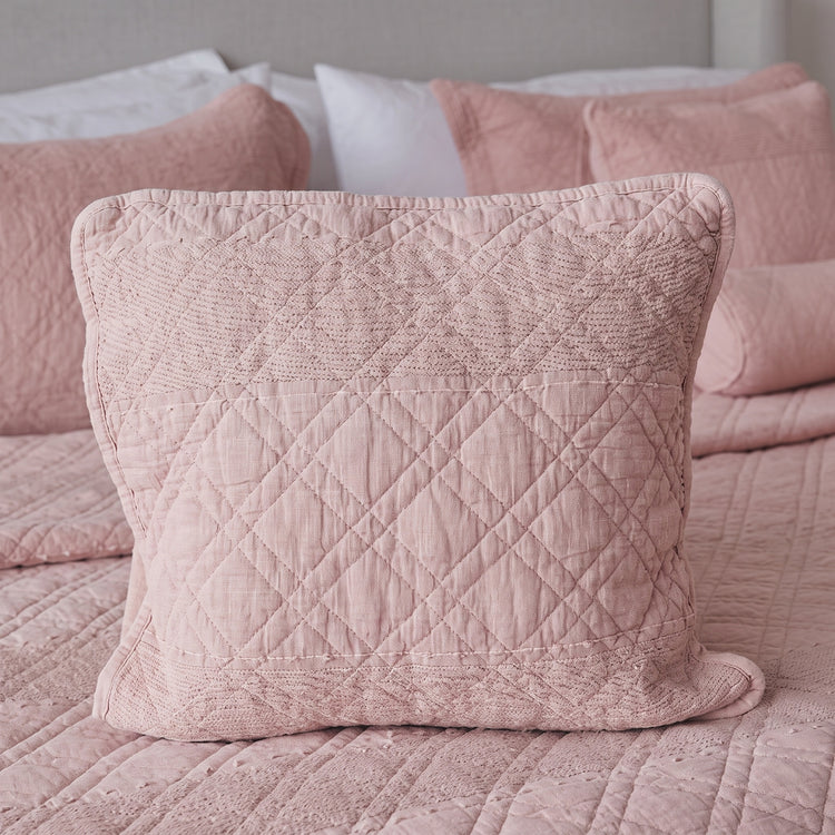 funda de almohadón cuadrado sobre cama en trama manchester-rosa