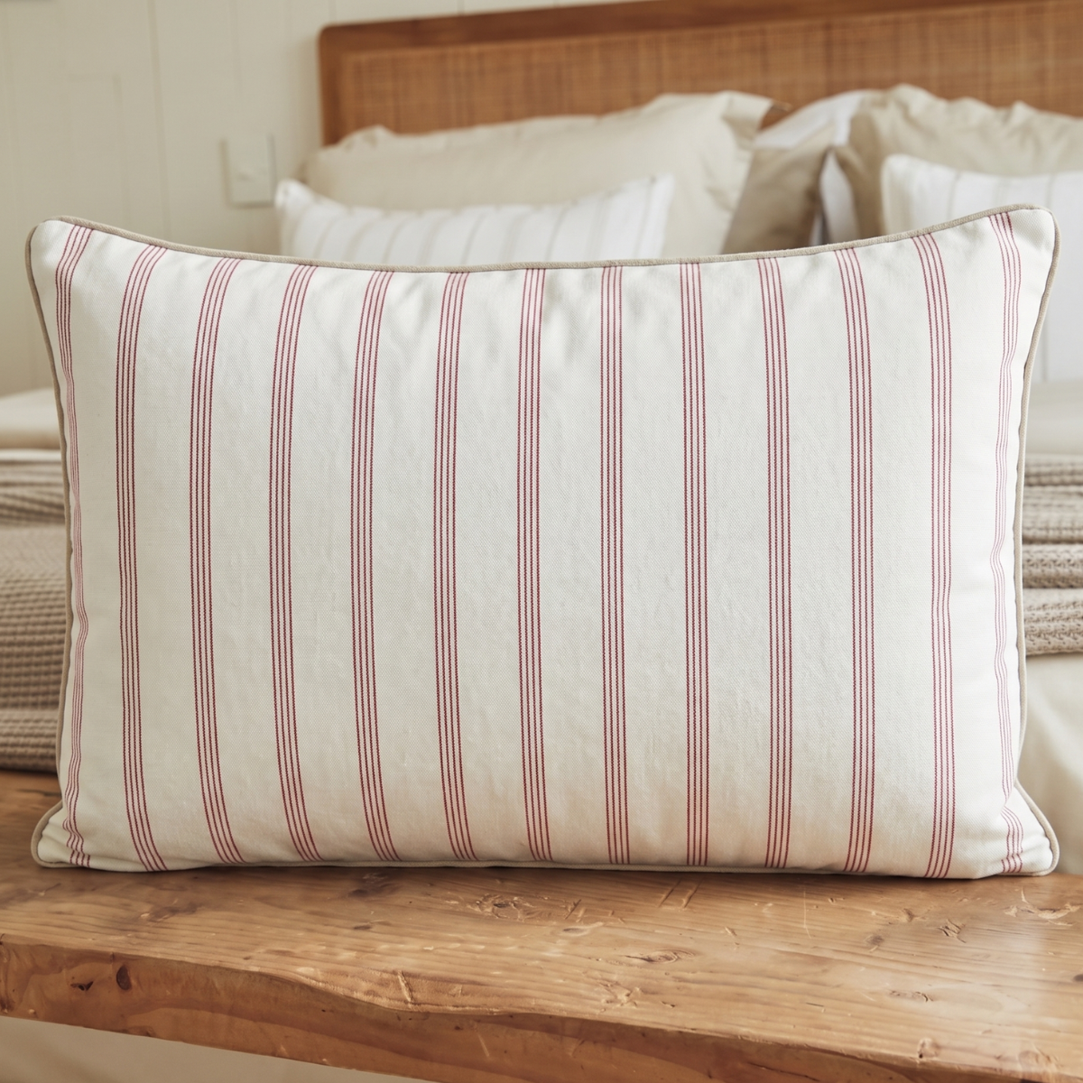 Almohada con rayas finas rosas y blancas sobre cama de madera-rosa
