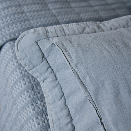 Detalle de funda almohada gris con costura y textura de tela-gris
