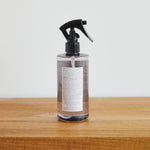 
                    
                      Botella spray de producto textil color marrón sobre superficie de madera-peonia
                    
                  