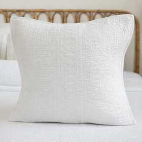 Funda de almohada blanca texturizada sobre cama con cabecero de madera-blanco