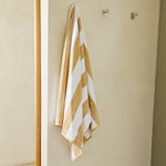 
                    
                      Toalla de playa con rayas beige y blancas colgada en pared-beige
                    
                  