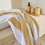 
                    
                      Toalla de playa con rayas beige y blancas colgada en bañera-beige
                    
                  