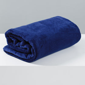 Frazada polar azul oscuro enrollada sobre fondo blanco-azul