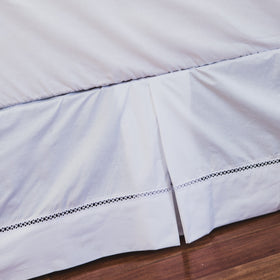 Cubresommier blanco con encaje decorativo sobre piso de madera-blanco