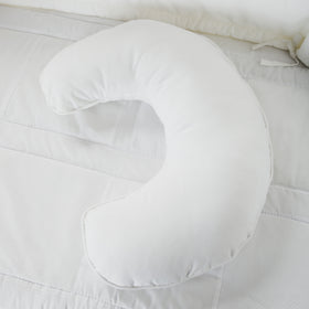 Almohada blanca de forma de media luna sobre cama blanca-blanco