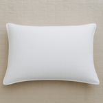 
                    
                      Almohada blanca rectangular con relleno esponjoso sobre fondo beige-blanco
                    
                  