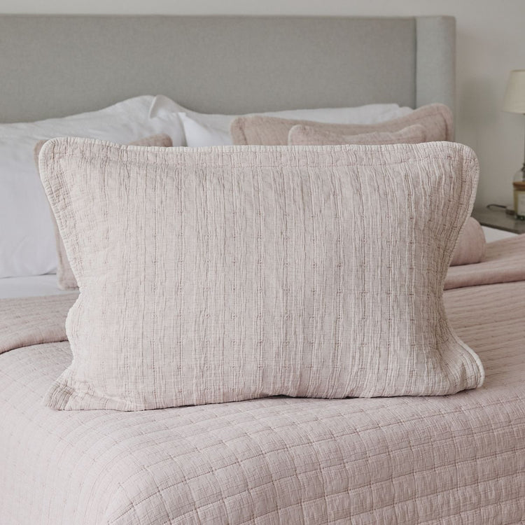 Funda de almohada Cardiff en tonos beige sobre cama con ropa de cama-