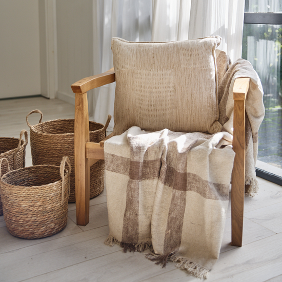 Almohada beige Agra en silla de madera con manta a cuadros-beige